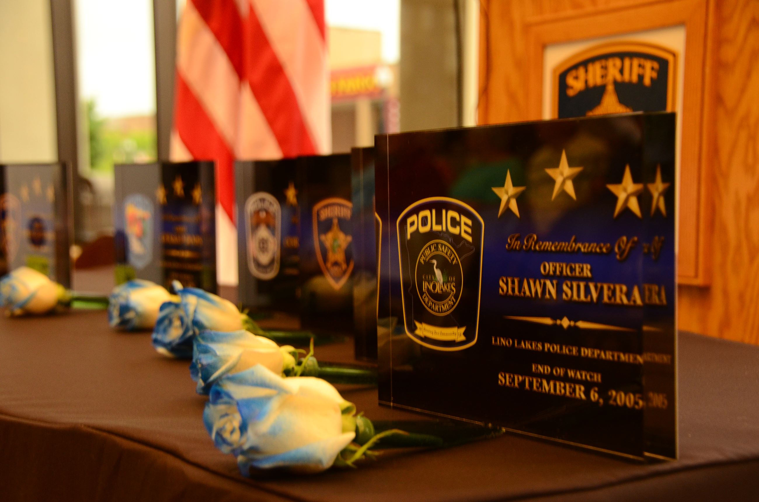 Flowers on table in front of memorial plaque
