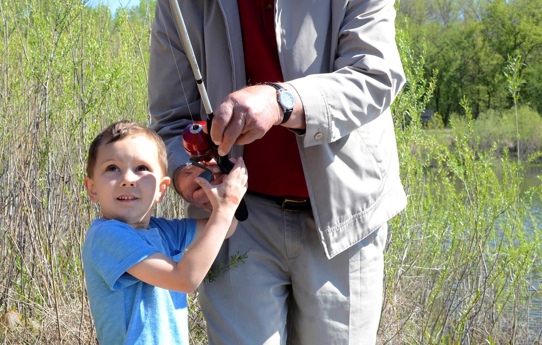 Child and adult hold fishing rod