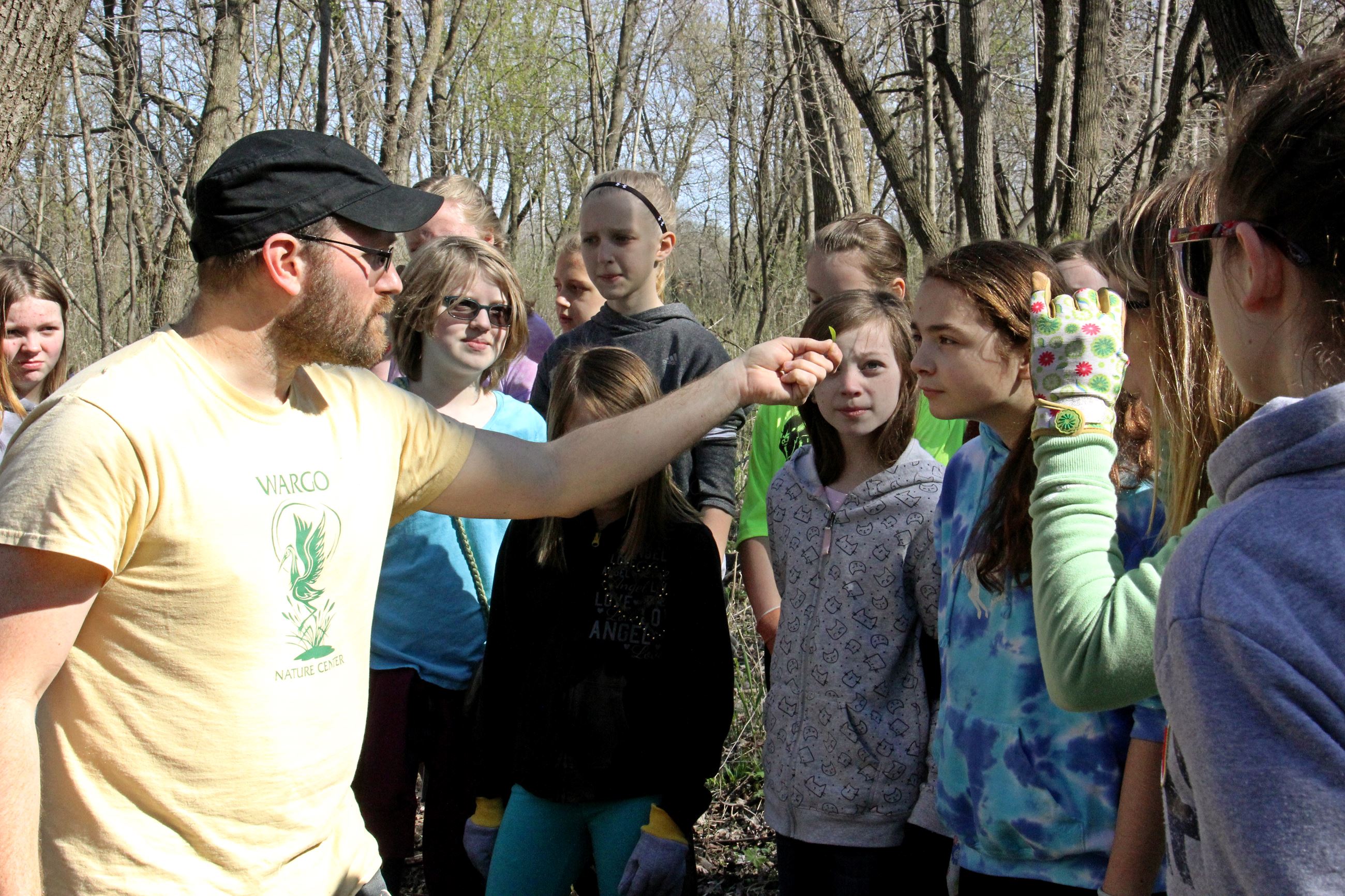 Naturalist holds leaf for children to examine