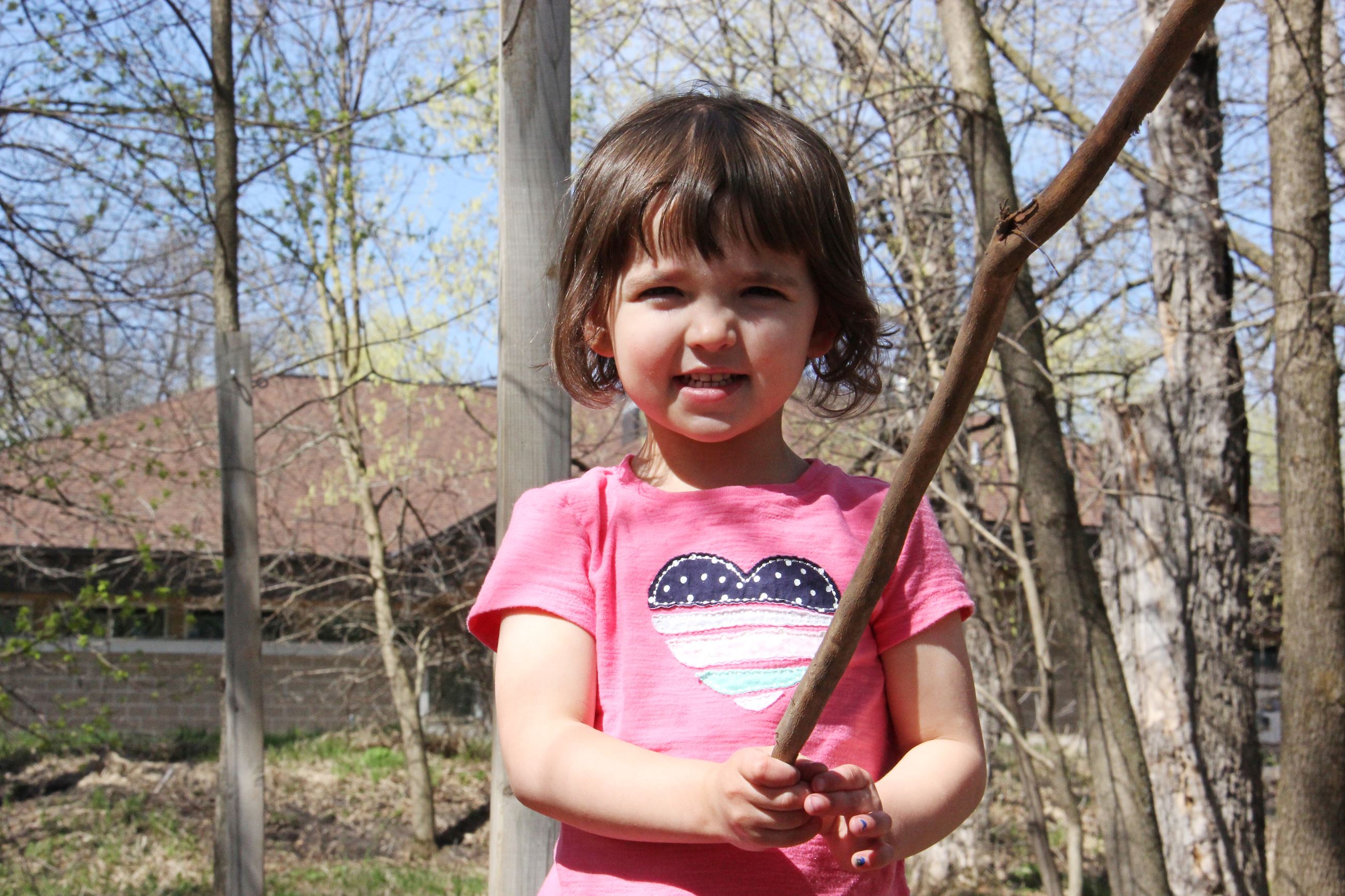 Little girls holds a branch