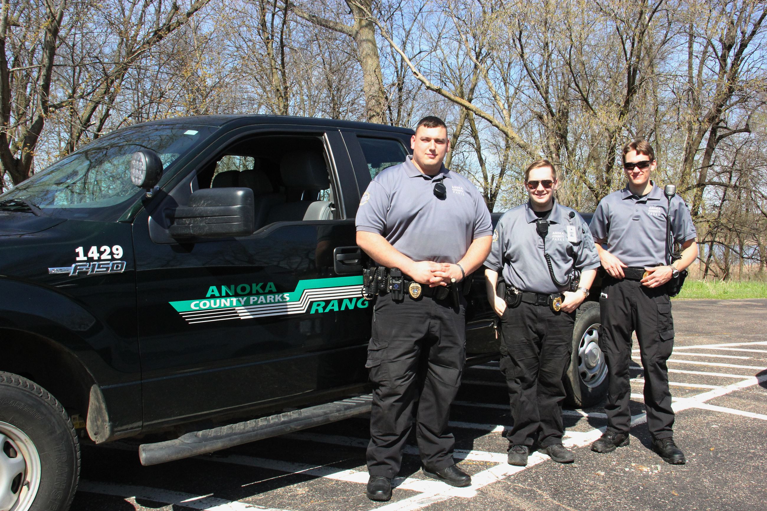 Anoka County Park Rangers stand in front of truck
