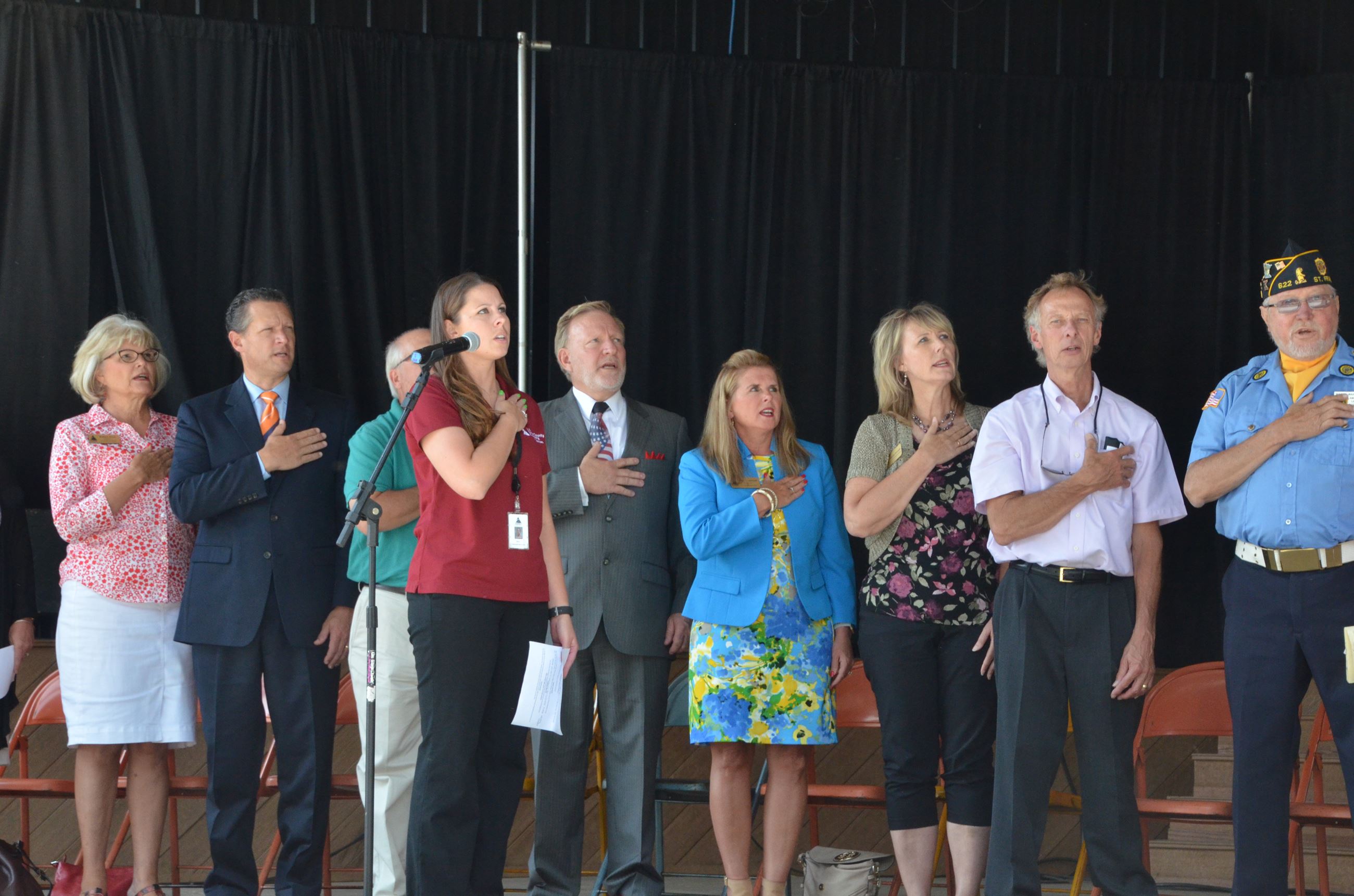 Public officials on stage saying pledge of allegiance 