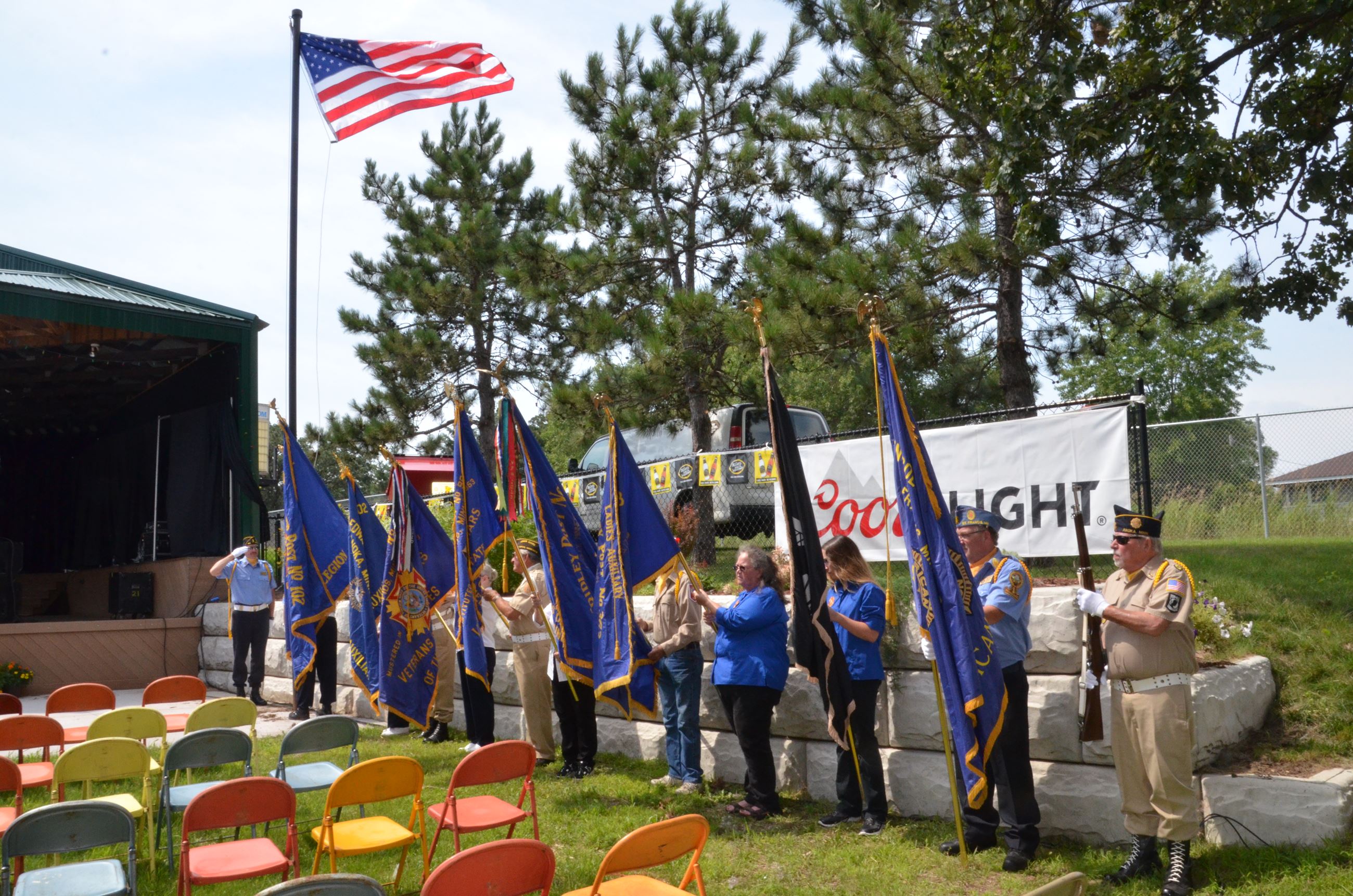 Honor guard members raise flags