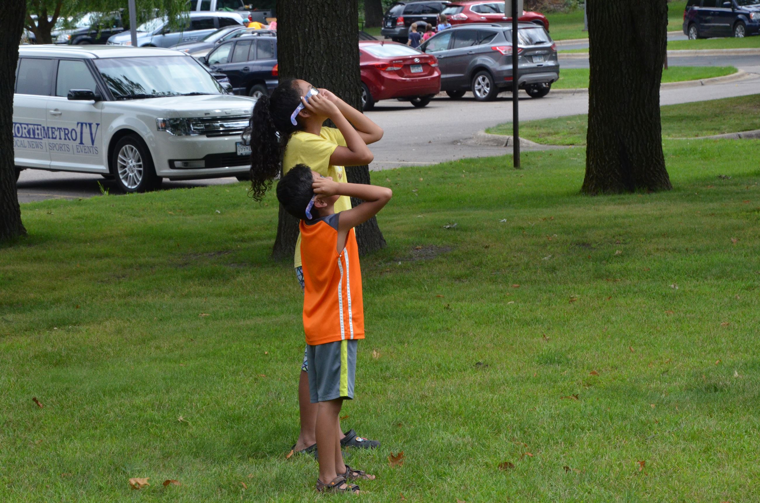Children trying their new eclipse glasses.