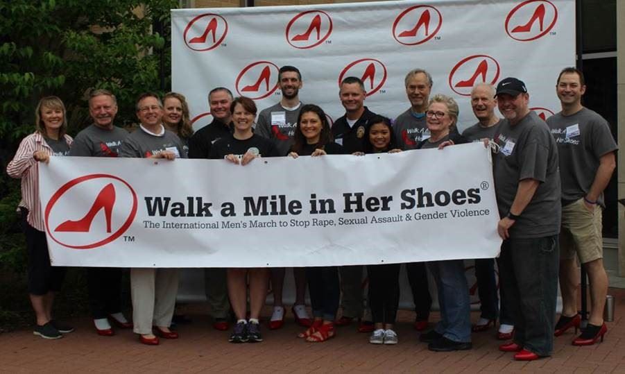 Walk a Mile in Her Shoes Team with Comm. Sivarajah and Comm. Schulte holding the banner